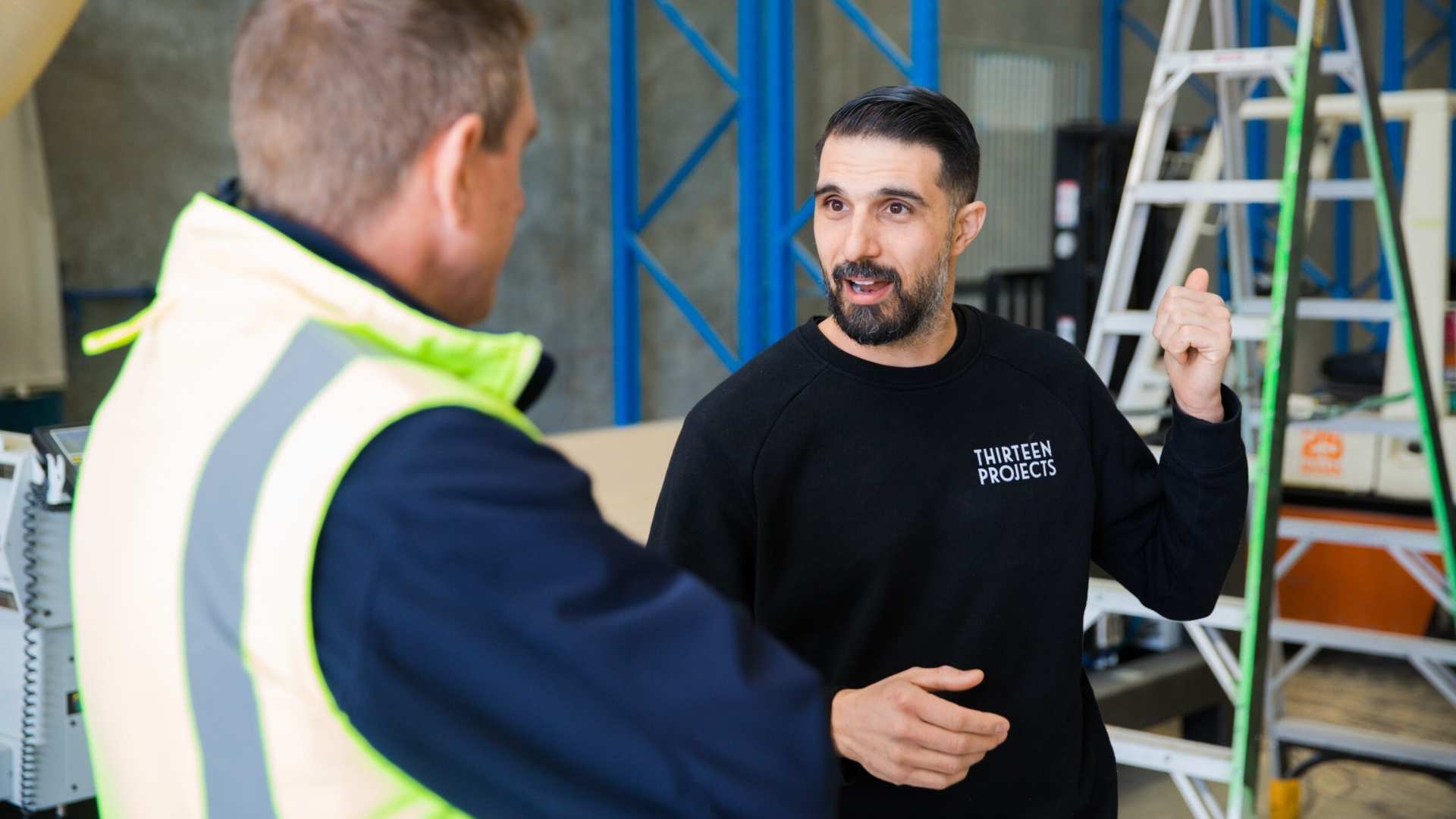 Thirteen projects employee in conversation with Bowens account manager on site.
