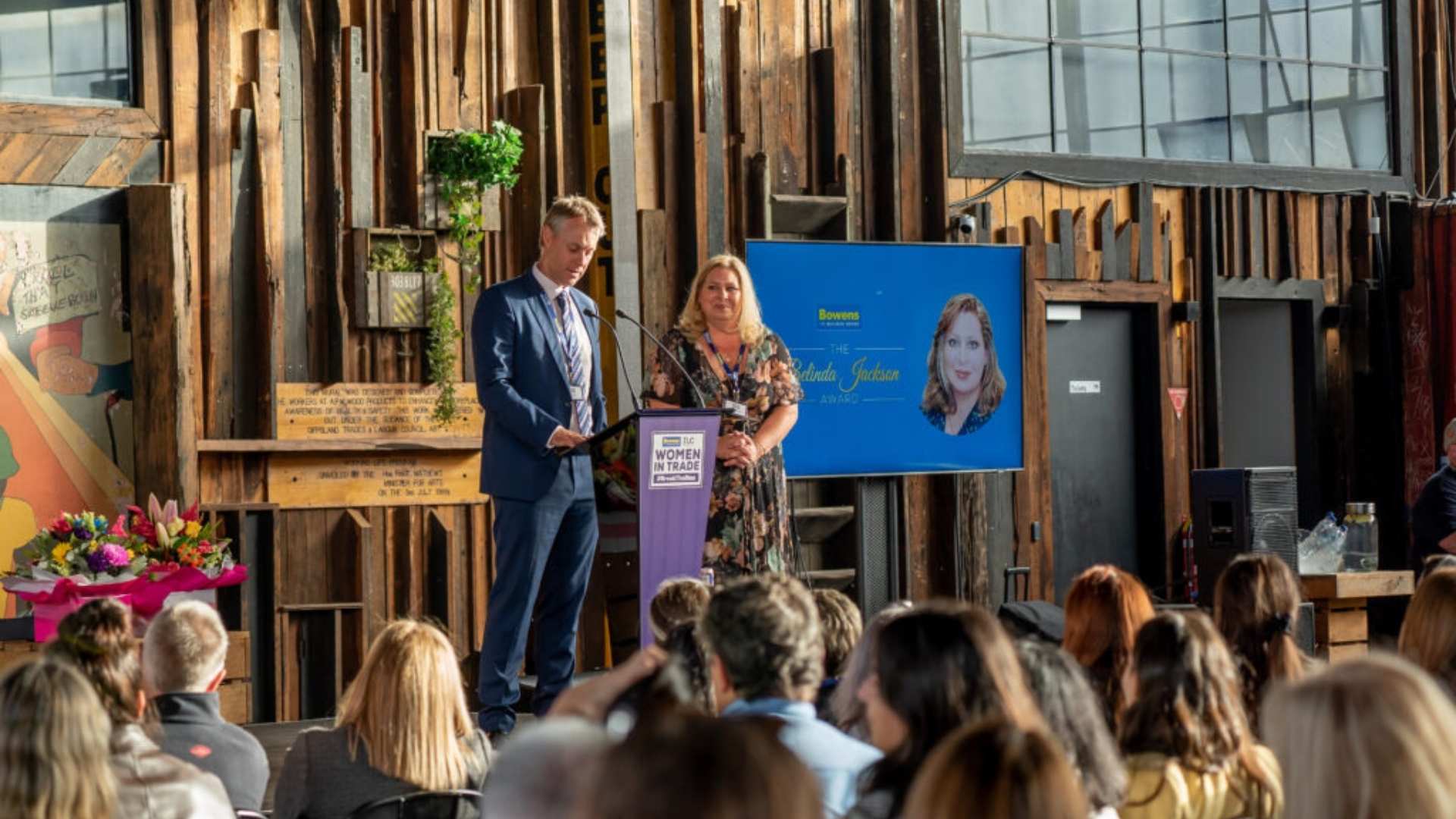 Director, John Bowen, and Belinda Jackson on stage presenting the Belinda Jackson award.