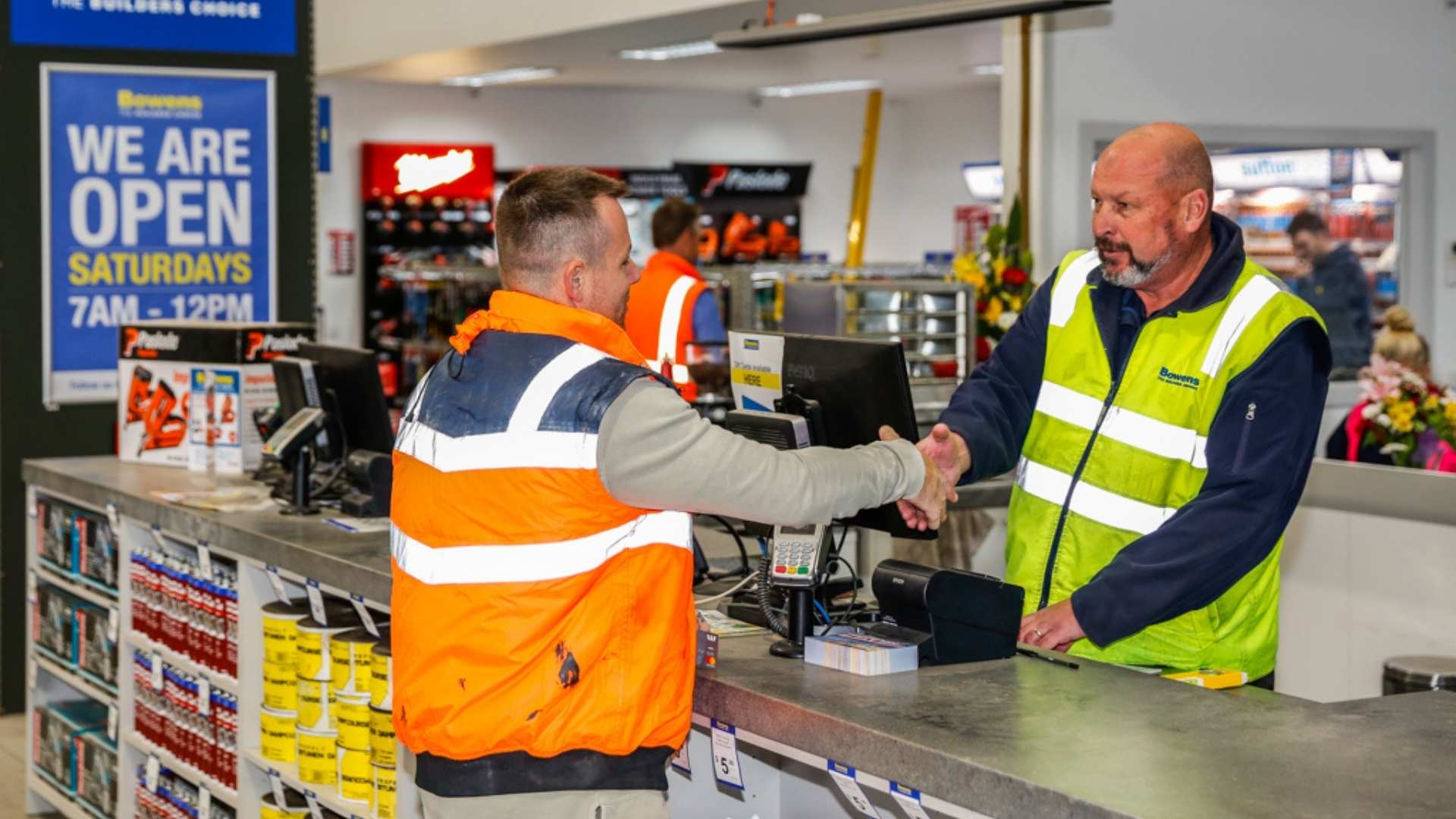Builder shaking hands with Bowens staff at counter.