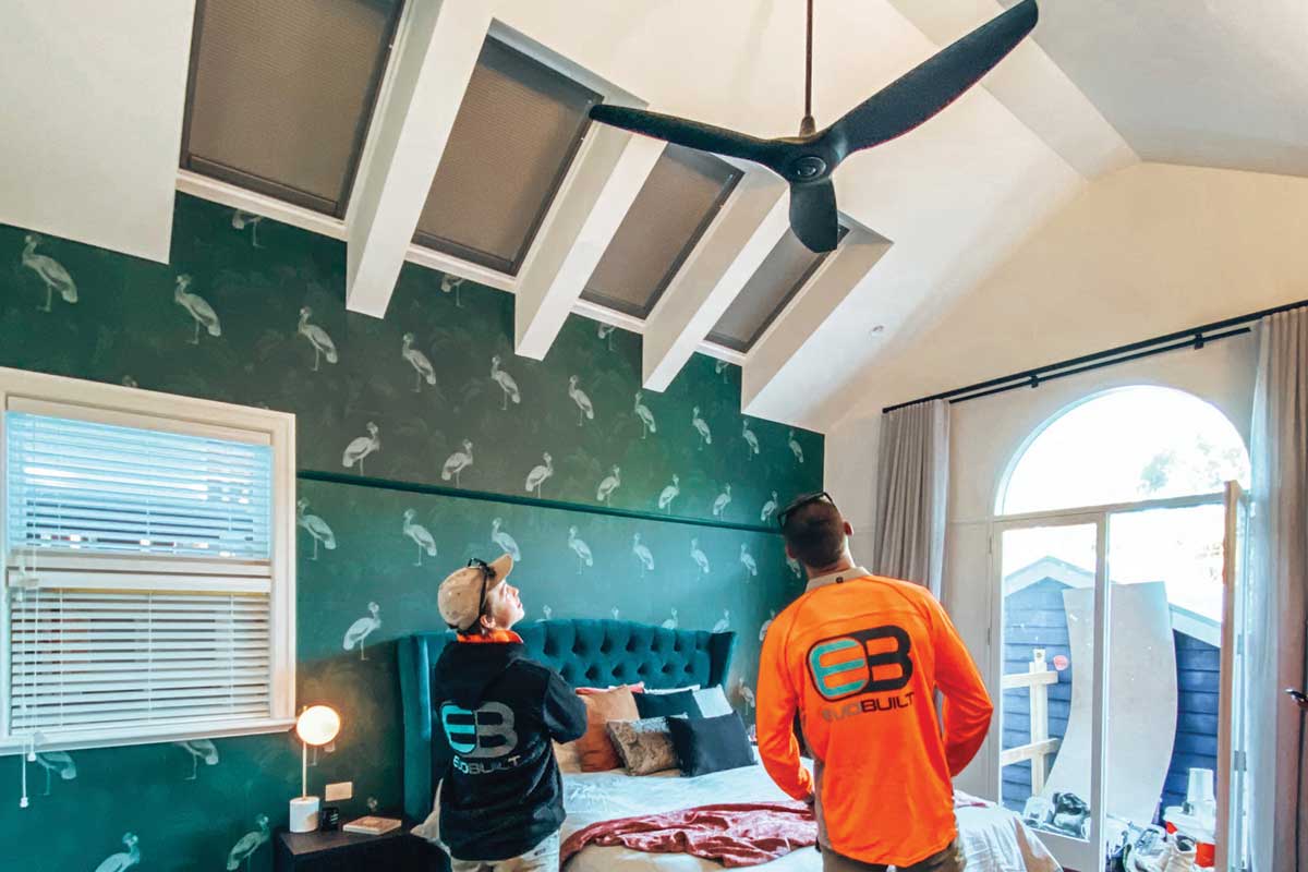 2 builders standing in the bedroom checking the ceiling of a home