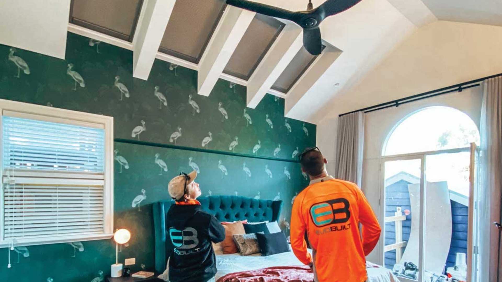 Two builders standing in the bedroom checking the ceiling of a home.