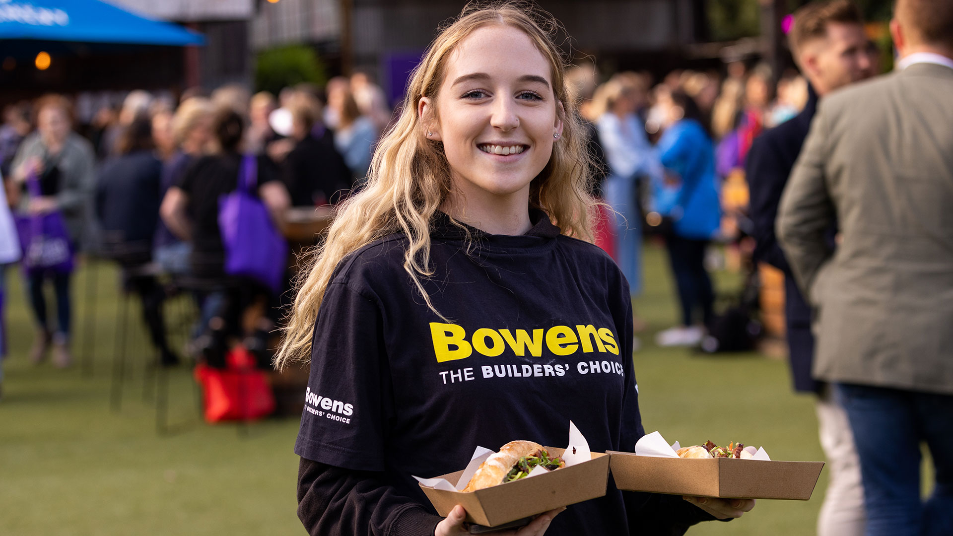 Girl holding food smiling at camera at Bowens Women in Trade 2023.