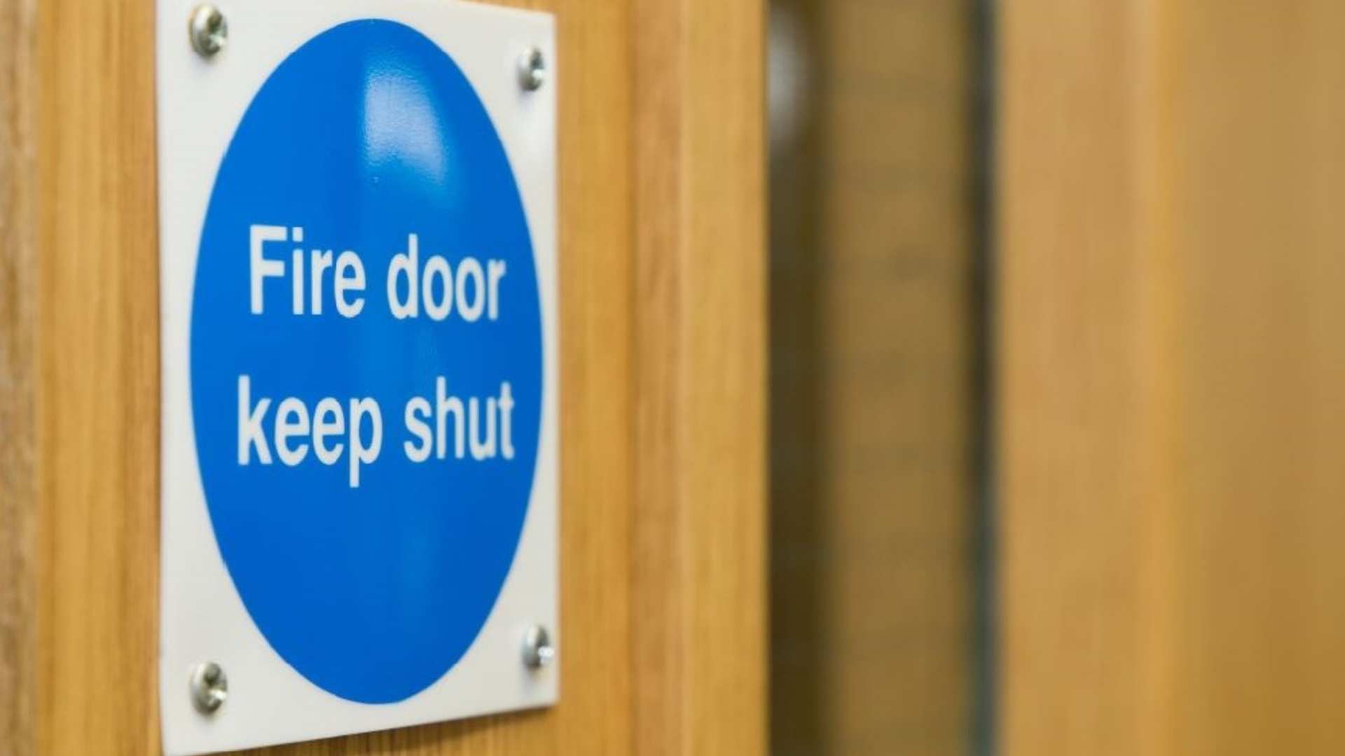 Close up of 'fire door keep shut' sign in commercial setting.