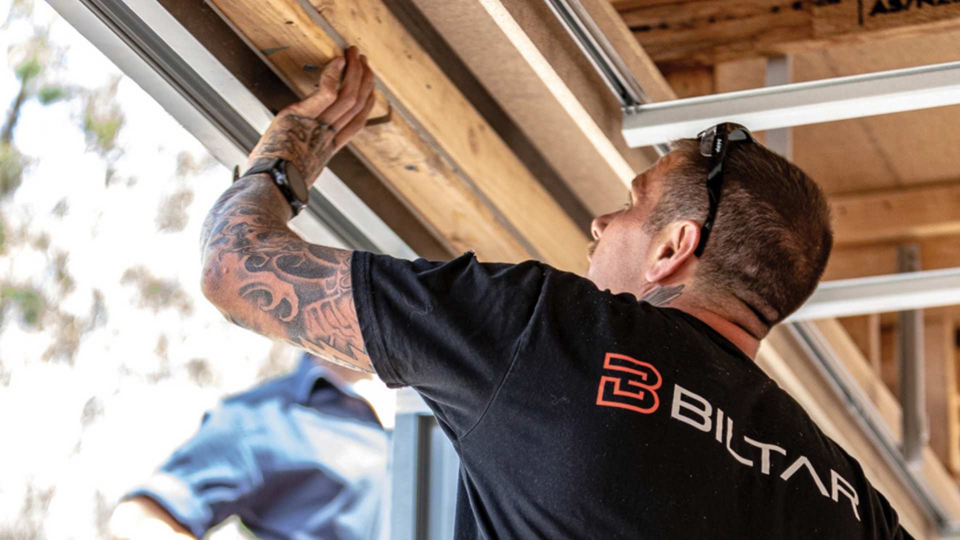 Builder installing timber framing on residential job site. 