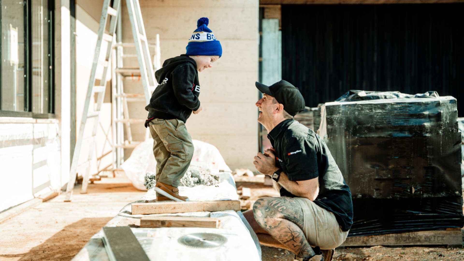 Builder and child sharing a moment on jobsite. 