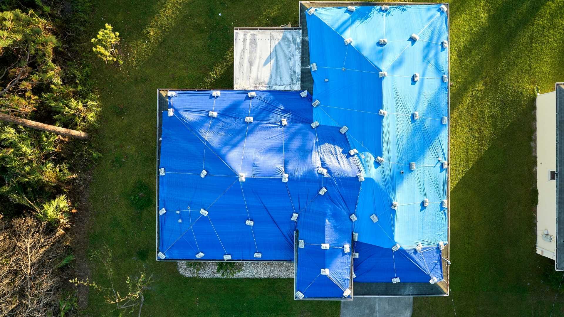 Tarps displayed on roof of residential home to keep weather out, especially in colder months.