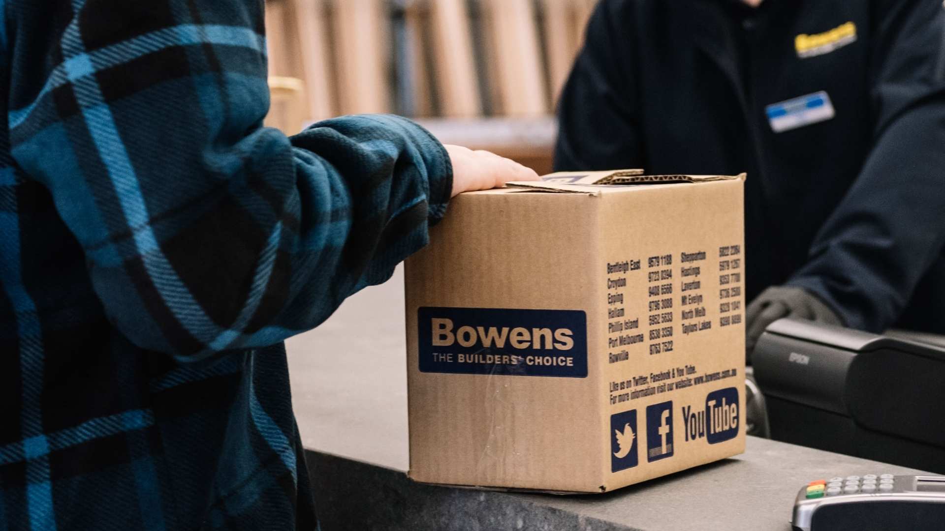 Trade customer at service desk collecting a box from Bowens store.