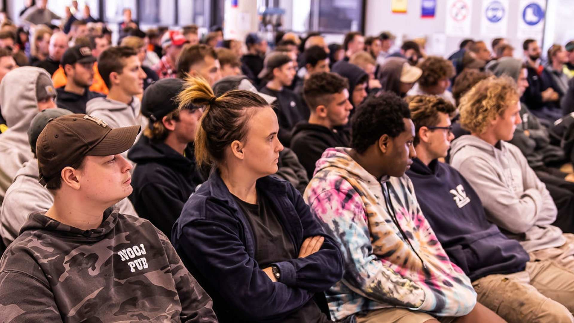 Tradies sitting in the audience for a mental health seminar.