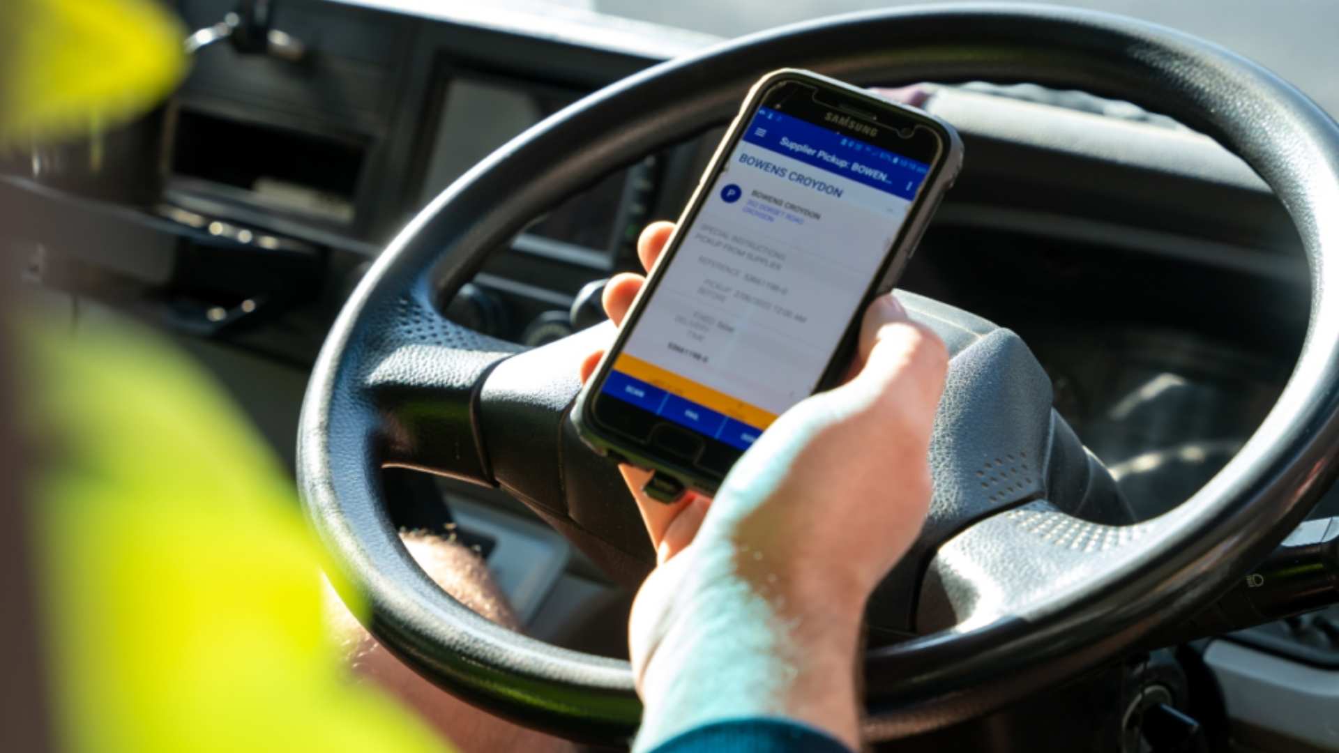 Truck driver checking deliveries on mobile.