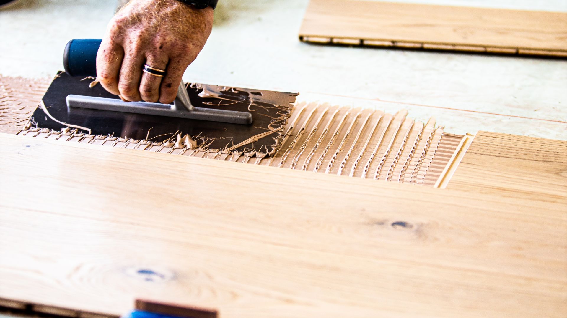A man installing an engineered timber flooring, preparing it for finishing.