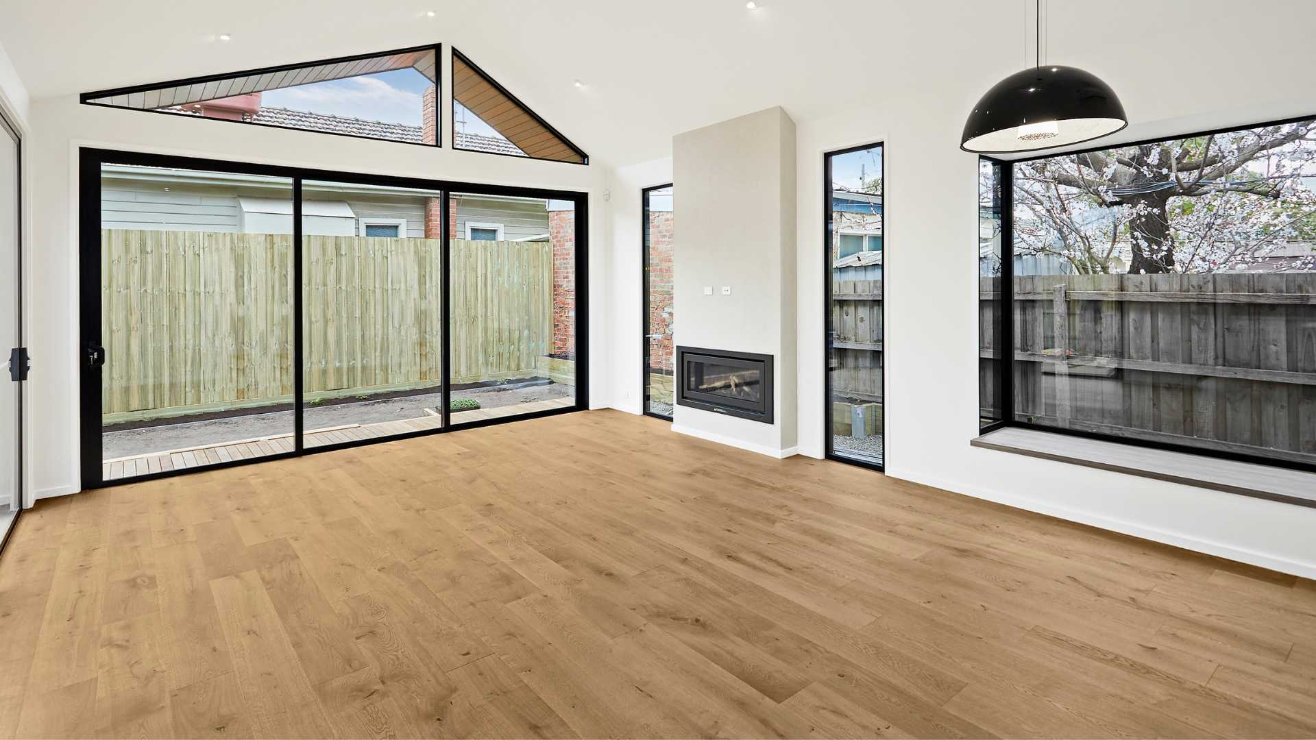 A room with timber flooring and glass doors. Timber flooring acclimatisation is important.