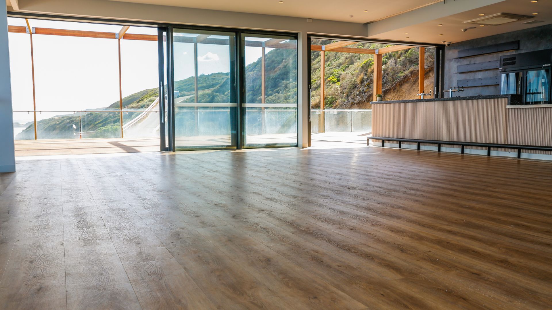 A spacious room with timber floors and expansive windows, showcasing timber expectations between supplier, builder and homeowner.