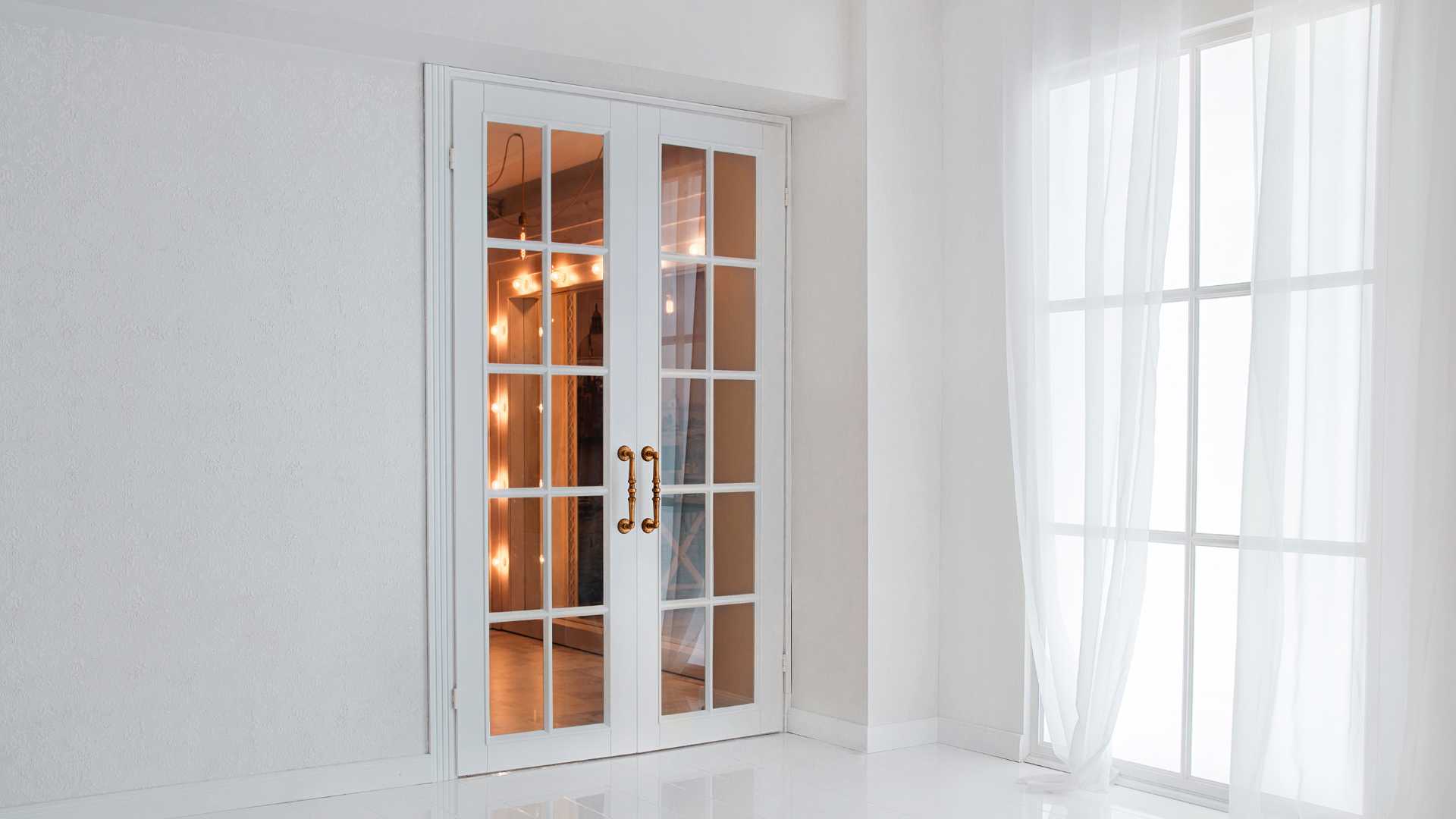 A white room with an internal French door and a window.
