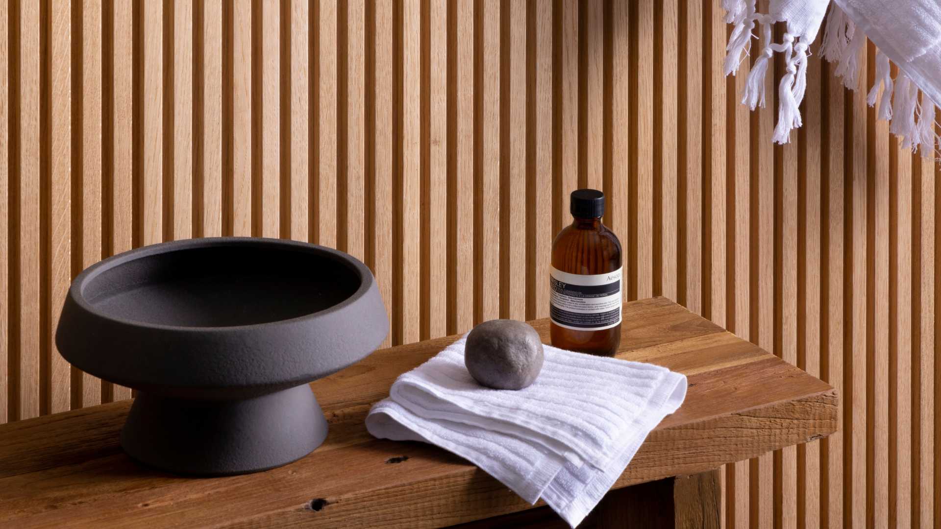 Wooden table with towel, bottle, and bowl against interior Porta Contour interior wall lining.