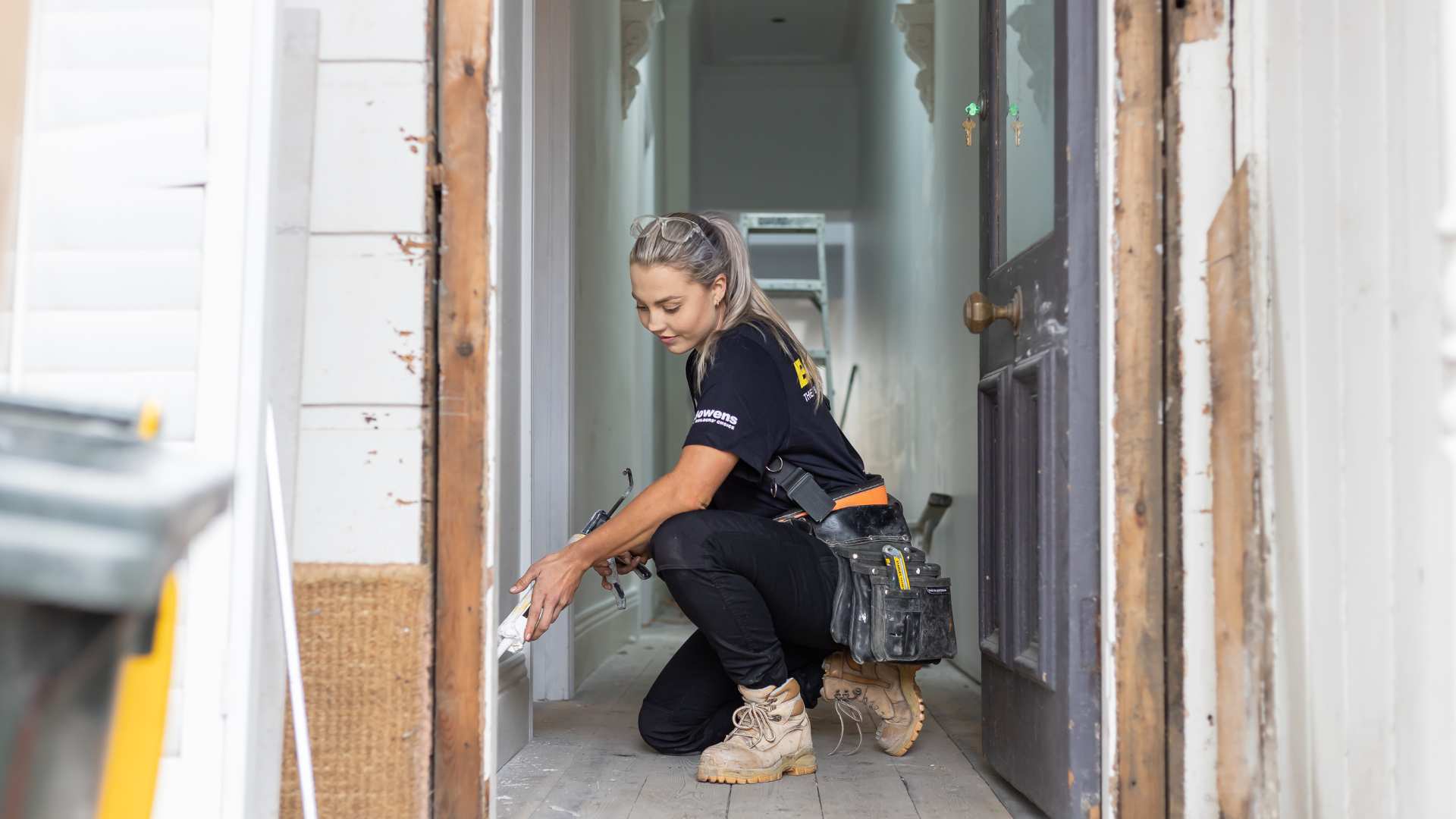 Trade installing skirting board at job site.