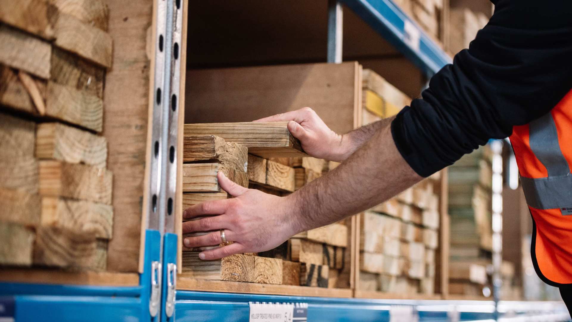 Close up of a man selecting treated timber from bay.