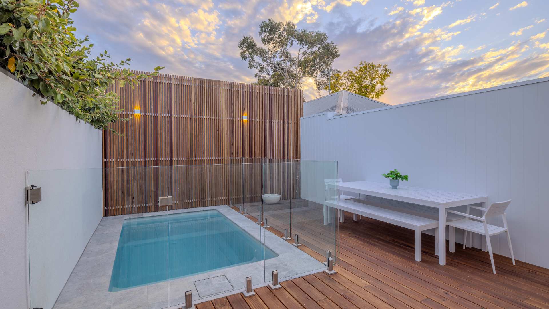 Blackbutt decking used in residential backyard with a pool, a dining table, and a beautiful sky.