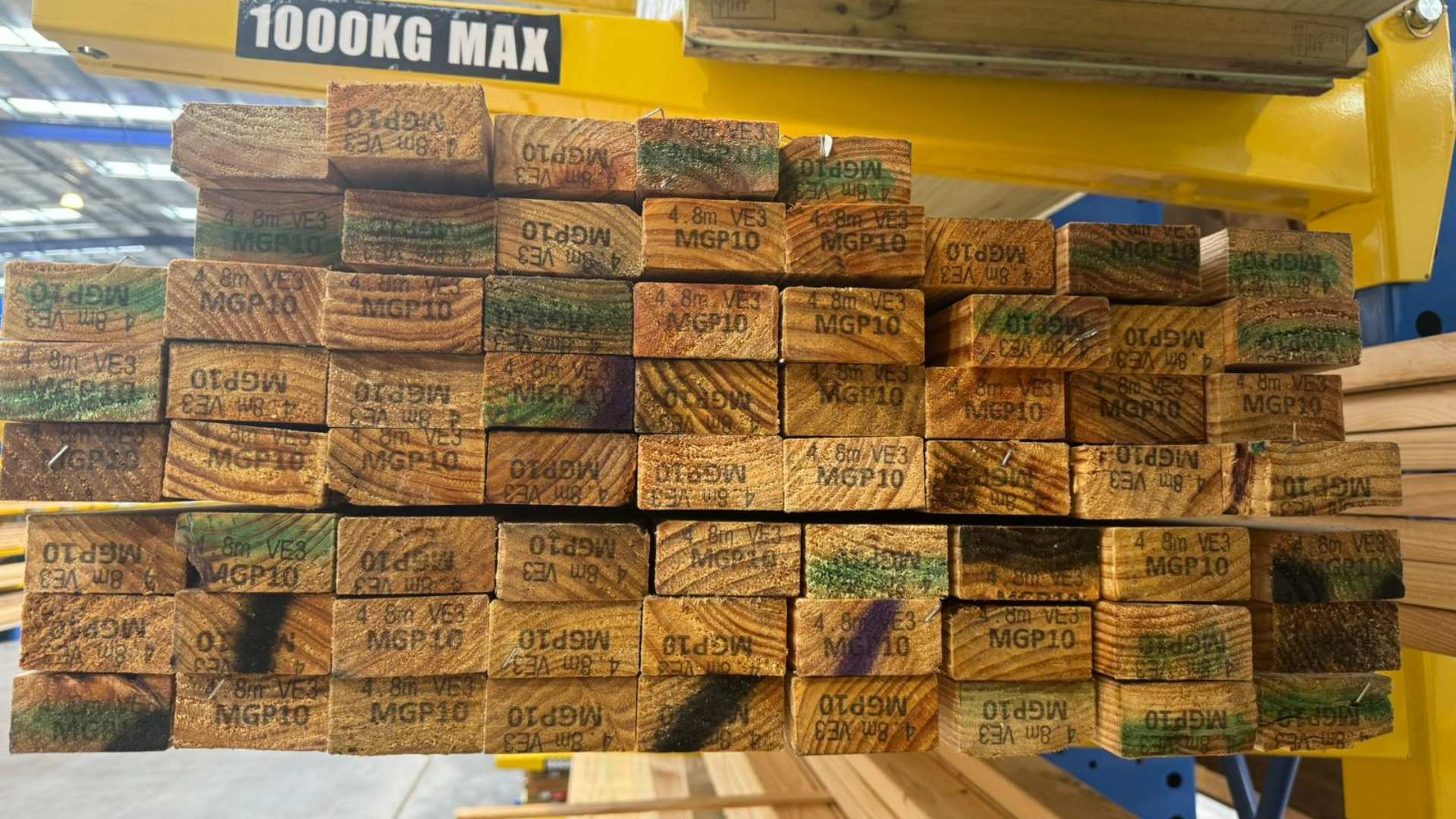 Treated pine front on profile as it is stacked together on racks in warehouse showcasing the grain.