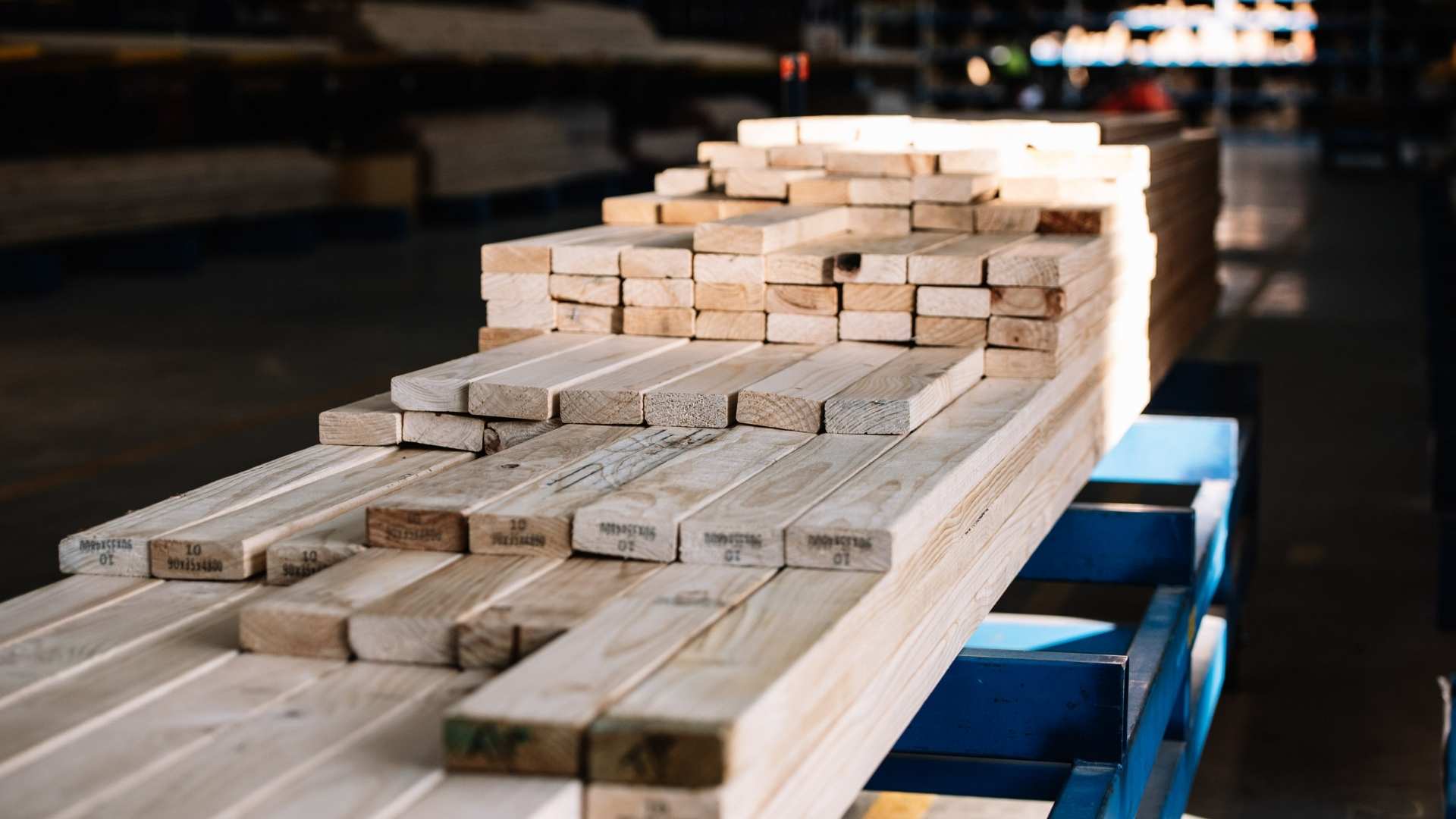 Pine framing timber stacked on racks at warehouse.