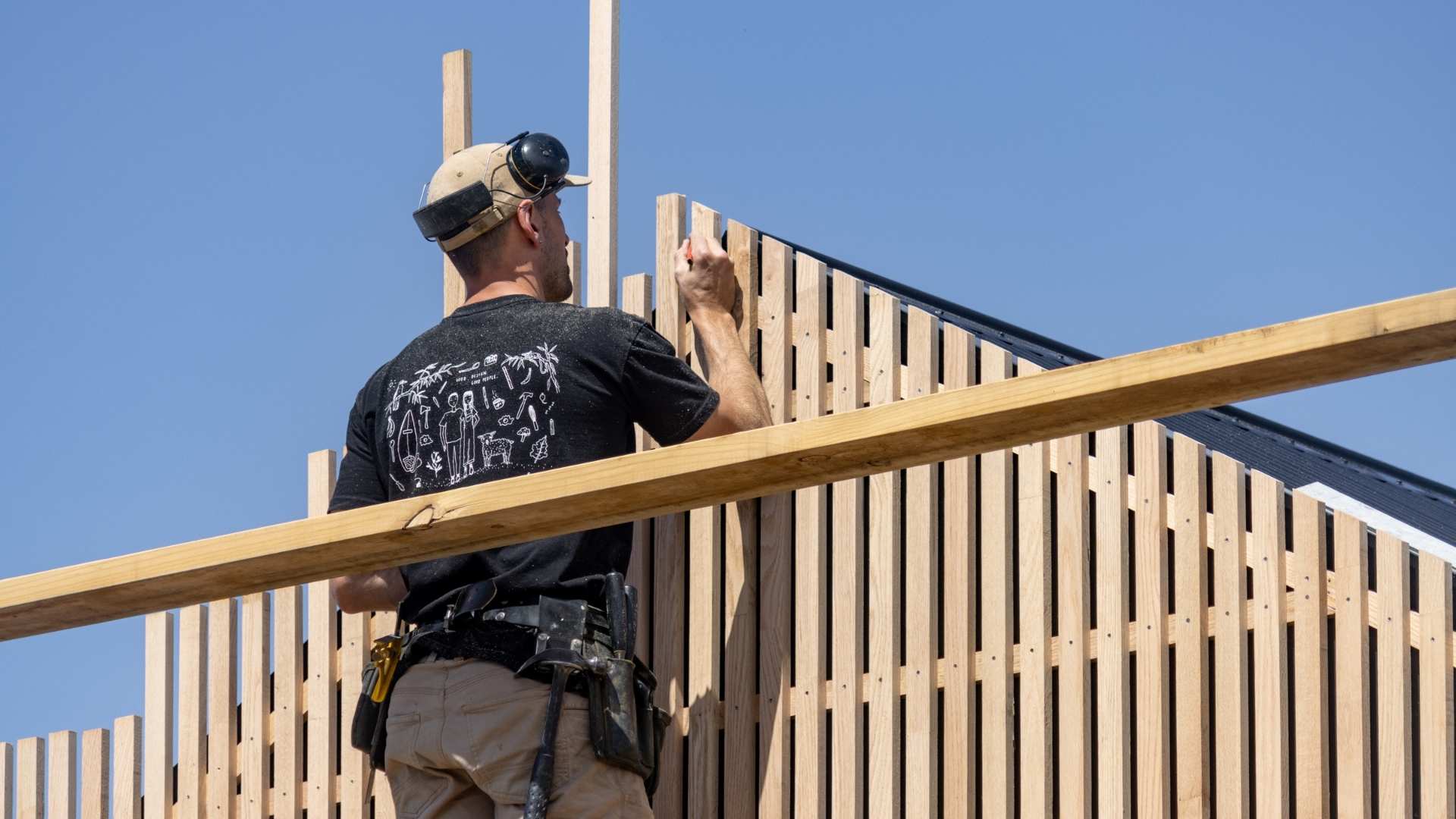 Close up of Al measuring sustainable cladding battons.