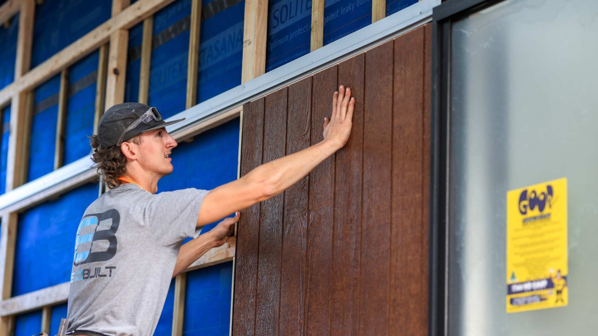 Trade installing Weathertex composite cladding at jobsite.