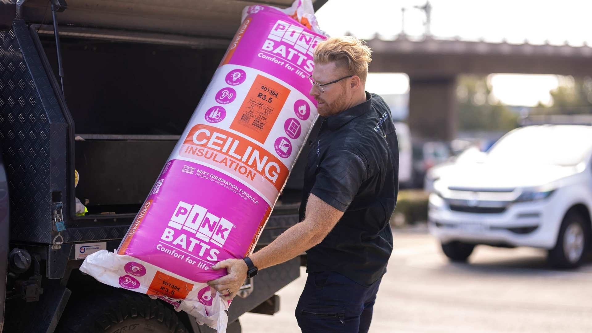 Builder with ceiling insulation batt about to load into Ute.