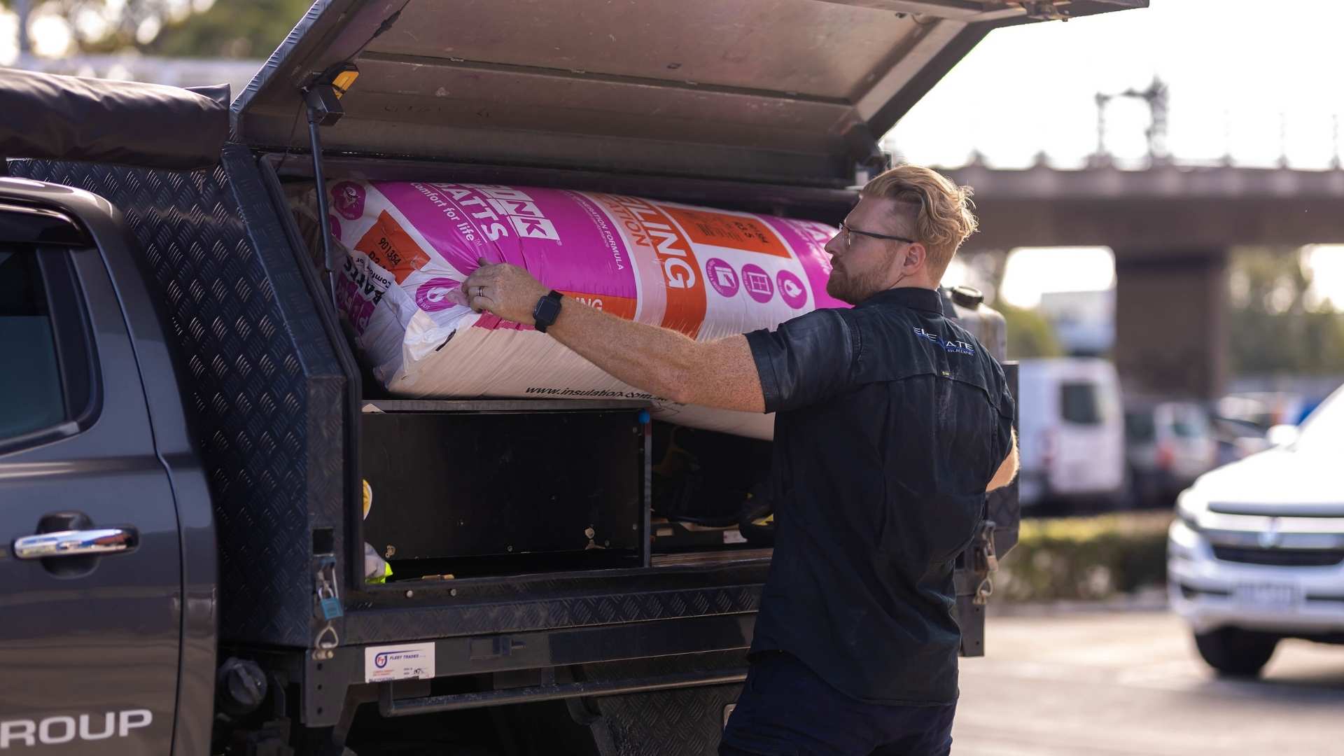 Builder putting insulation batts into his ute.