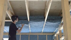 Trade installing Planet Protector's denim insulation in roof.