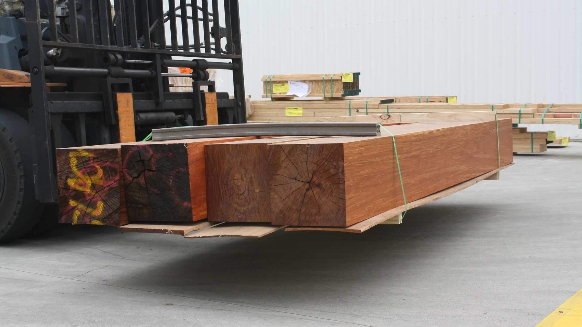 Timber posts/beams on forklift being transported in timber yard.